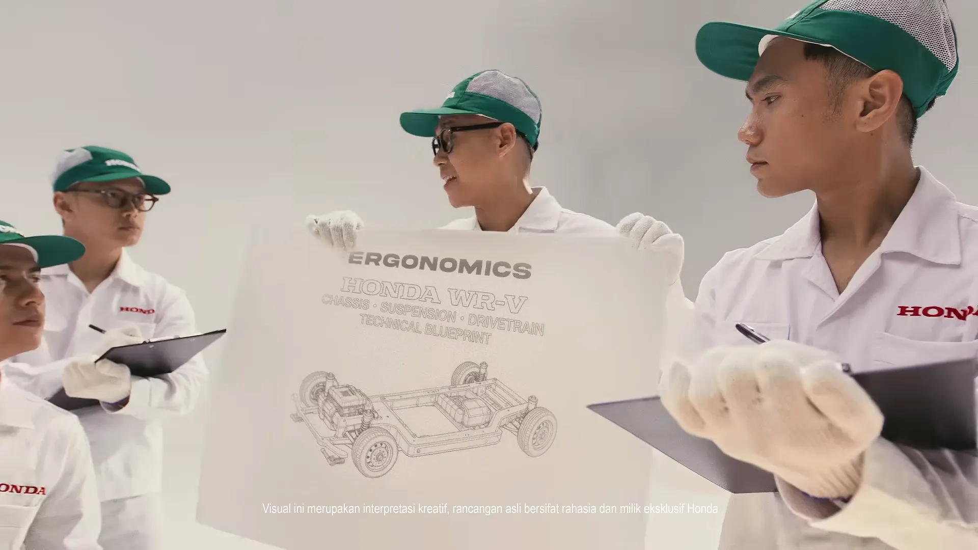 Honda engineers in green caps reading an ergonomics blueprint of the WR-V